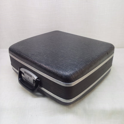 Black hard-shell typewriter case on a white background.