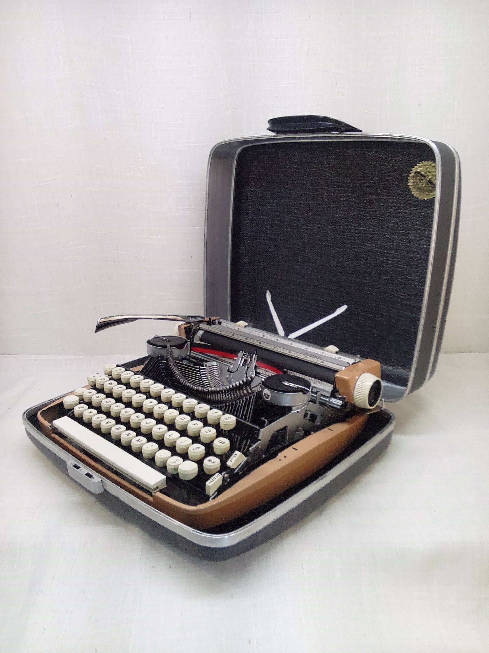 Vintage Smith Corona typewriter in a carrying case on a white background